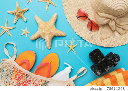 Flat composition with different accessories for a beach holiday on a blue background, summer background Flat composition with different accessories for a beach holiday on a blue background, summer background 78611248
