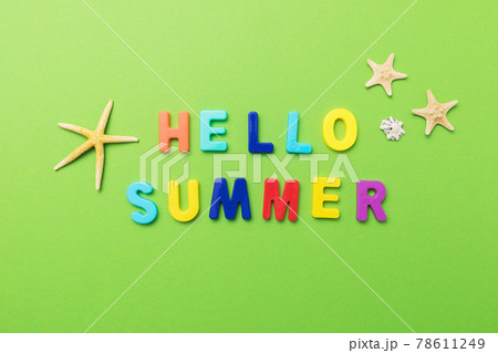 The inscription from multi-colored plastic letters with starfish on a green background 78611249