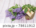 Victory Day. 9th May. A bouquet of lilacs, old photos and a soldier's cap / On the photo is a dummy of a soldier's cap 78611912