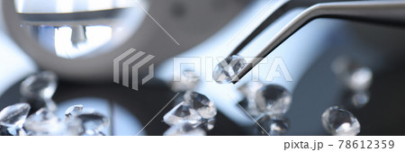 Closeup of diamond stone in metal tweezers 78612359