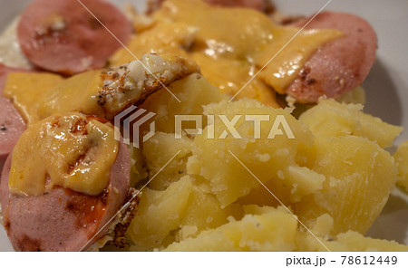 Eggs au gratin with cheese on meat sausage with boiled potatoes, bachelor meal 78612449