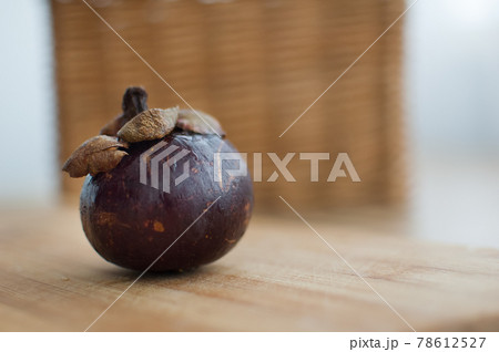 Mangosteen fruit with dark purple skin on wooden table, the queen of exotic fruits. Healthy eating concept 78612527