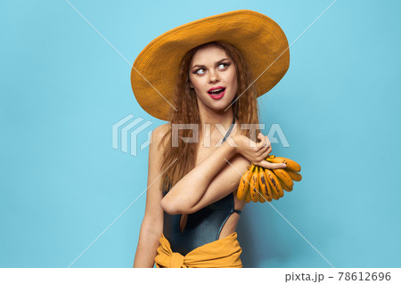 Woman in swimsuit hat exotic fruits summer fun blue background 78612696