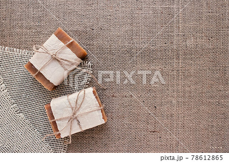 Top view on handmade natural soap bars or dry shampoo with on rustic fabric background with copy space. Close up of home spa products made with natural ingridients and organic essential oils 78612865
