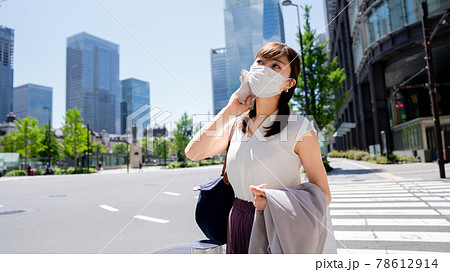 暑くて汗を拭くマスク姿の女性 78612914