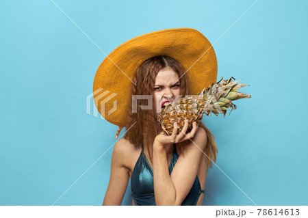 woman in beach hat pineapple holding swimsuit exotic fruits blue background vacation woman in beach hat pineapple holding swimsuit exotic fruits blue background vacation 78614613