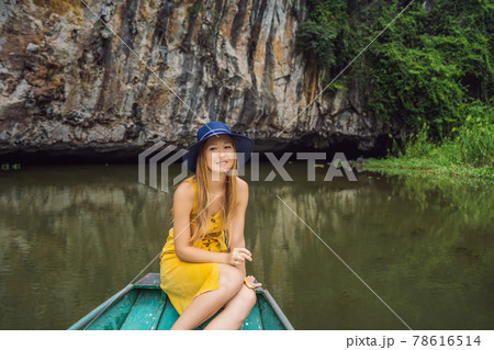 Woman tourist in boat on the lake Tam Coc, Ninh Binh, Viet nam. It's is UNESCO World Heritage Site, renowned for its boat cave tours. It's Halong Bay on land of Vietnam. Vietnam reopens borders after 78616514