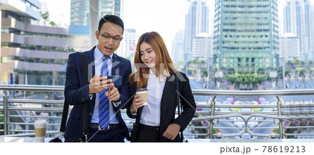Banner Businessman Businesswoman drinking coffee in town using smartphone outside office city. Panorama Hands holding take away coffee cup, smart phone talking together Business partner copyspace 78619213