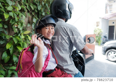 father taking his daughter to school by motorcycle in the morning father taking his daughter to school by motorcycle in the morning 78623710