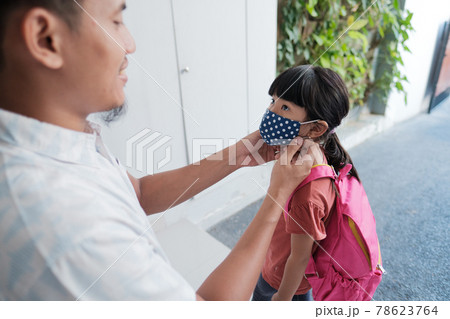 dad put a mask on her daughter for protection against corona virus dad put a mask on her daughter for protection against corona virus 78623764
