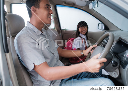 dad taking her daughter to school in the morning by driving a car 78623825