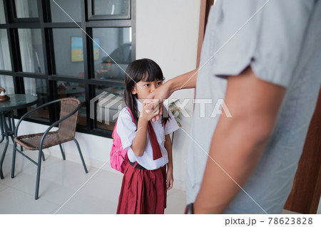 indonesian primary school female student shake and kiss her father's hand before going to school indonesian primary school female student shake and kiss her father's hand before going to school 78623828