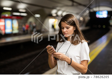 Woman holding smartphone in underground Woman holding smartphone in underground 78626205