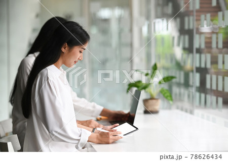 Young startup business group working as team to find solution to problem and using tablet with white screen. Young startup business group working as team to find solution to problem and using tablet with white screen. 78626434