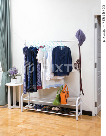 woman clothes hanging on clothes rack in room interior 78626755