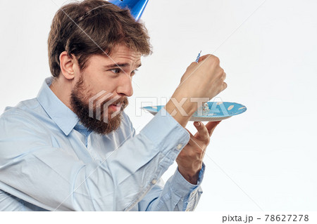 A man with a cake plate and in a blue shirt on a light background birthday party corporate cap A man with a cake plate and in a blue shirt on a light background birthday party corporate cap 78627278