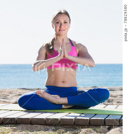 Woman practicing of yoga on the beach 78629380