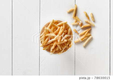 Crispy french fries in bowl on white wooden background Crispy french fries in bowl on white wooden background 78630015