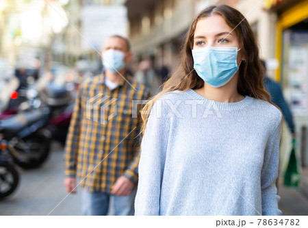 Woman in protective face mask posing on the street 78634782