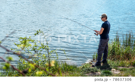 Fisherman with spinning rod on nature background. Angler man with fishing spinning or casting rod by the river. Fisherman with rod, spinning reel on the river bank Fisherman with spinning rod on nature background. Angler man with fishing spinning or casting rod by the river. Fisherman with rod, spinning reel on the river bank 78637306