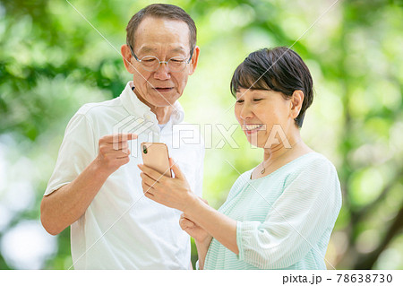 スマホを持つシニア夫婦　新緑 78638730