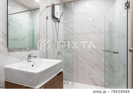 White Modern Bathroom with Shower Cabin Glass and Big mirror in Apartment. White Modern Bathroom with Shower Cabin Glass and Big mirror in Apartment. 78638889