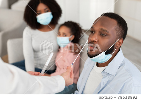 Doctor taking PCR test sample from potentially infected black man 78638892