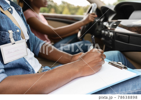 Driving Instructor Writing Down Results Of Exam, driving school concept Driving Instructor Writing Down Results Of Exam, driving school concept 78638898