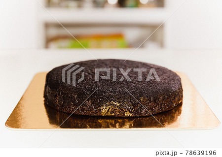 Freshly baked sponge chocolate cake with on golden paper board. 78639196