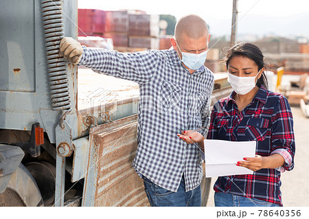 Woman manager in face mask discussing order list with man worker 78640356