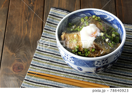 温玉とたっぷりの小ねぎがトッピングされた熱々の鰤の照り焼き丼を食べる 78640923