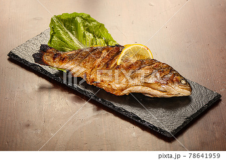 Grilled trout served lemon slice 78641959