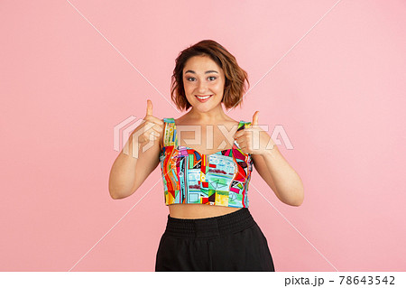 Portrait of young Caucasian beautiful woman in bright attire isolated on light pink background. Portrait of young Caucasian beautiful woman in bright attire isolated on light pink background. 78643542