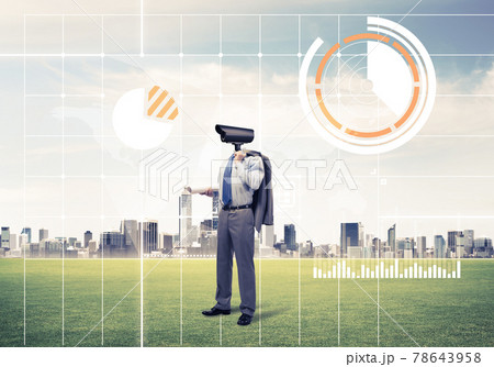 Camera headed man standing on green grass against modern citysca Camera headed man standing on green grass against modern citysca 78643958