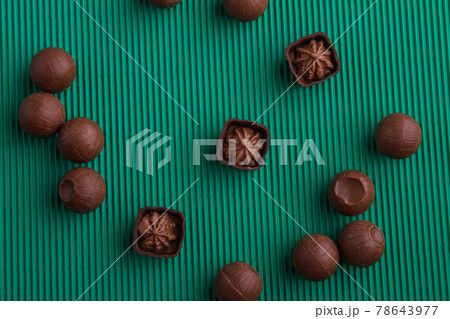 Top view brown praline chocolate candies on green background. 78643977