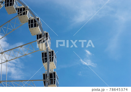 Ferris wheel cabins in a sunny day with white clouds Ferris wheel cabins in a sunny day with white clouds 78645374