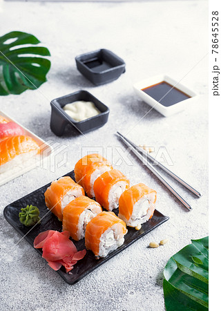 Philadelphia sushi roll made of fresh salmon, avocado and cream cheese inside. Traditional Japanese cuisine. Asian food Philadelphia sushi roll made of fresh salmon, avocado and cream cheese inside. Traditional Japanese cuisine. Asian food 78645528