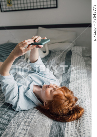 Young woman laying at the back making selfie alone at the bedroom Young woman laying at the back making selfie alone at the bedroom 78645775