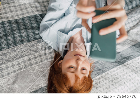Excited millennial female shooting herself with pretty faces on smartphone 78645776