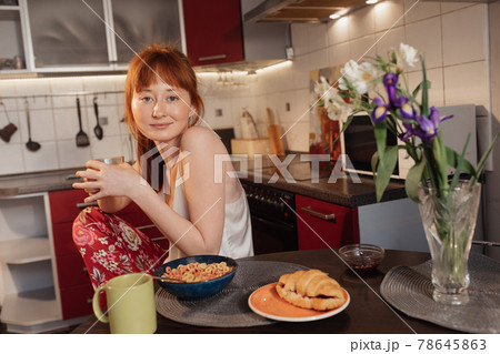 Woman having corn flakes with milk and sandwich at the breakfast Woman having corn flakes with milk and sandwich at the breakfast 78645863