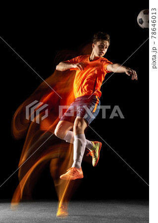 Young caucasian male football or soccer player kicking ball for the goal in mixed light on dark background. Concept of healthy lifestyle, professional sport, hobby. Young caucasian male football or soccer player kicking ball for the goal in mixed light on dark background. Concept of healthy lifestyle, professional sport, hobby. 78646013