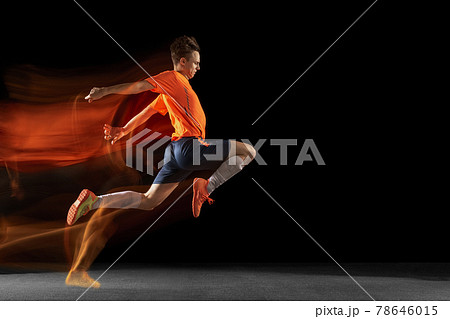 Young caucasian male football or soccer player kicking ball for the goal in mixed light on dark background. Concept of healthy lifestyle, professional sport, hobby. Young caucasian male football or soccer player kicking ball for the goal in mixed light on dark background. Concept of healthy lifestyle, professional sport, hobby. 78646015