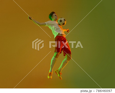 Young caucasian man, male soccer football player training isolated on gradient yellow green background in neon light Young caucasian man, male soccer football player training isolated on gradient yellow green background in neon light 78646097
