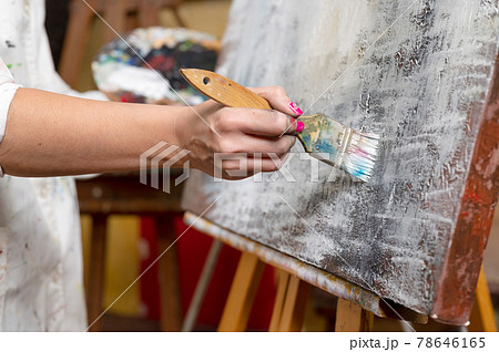 Close-up of an unrecognizable woman painter doing a brush stroke 78646165