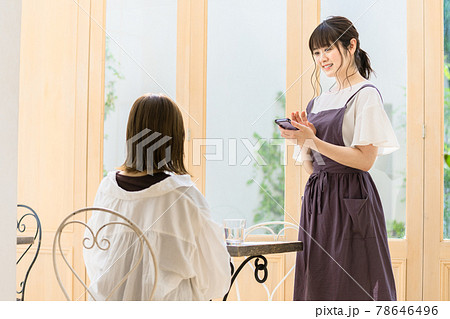カフェで注文を聴く若い女性店員 カフェで注文を聴く若い女性店員 78646496