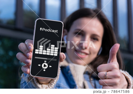 Podcast music. Happy young sexy girl holding mobile smartphone screen with podcast application, sound headphones. Audio voice with radio microphone in woman hand. Broadcast media music. Podcast music. Happy young sexy girl holding mobile smartphone screen with podcast application, sound headphones. Audio voice with radio microphone in woman hand. Broadcast media music. 78647586