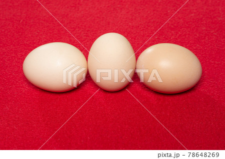 Whole eggs with set in a row on red background. 78648269