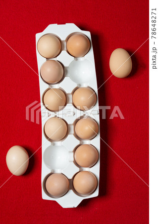 Eggs are laid in a plastic tray, red background. Eggs are laid in a plastic tray, red background. 78648271