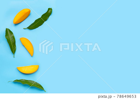 Tropical fruit, Mango slices with leaves on blue background. 78649653