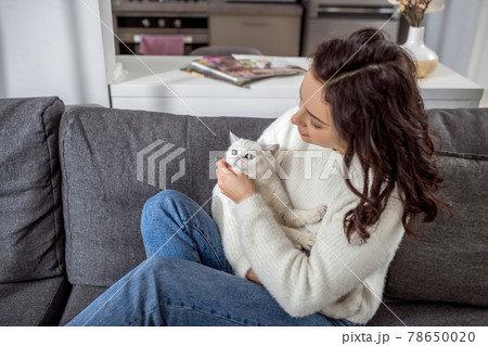 Cute young woman spending weekend at home with her cat Cute young woman spending weekend at home with her cat 78650020